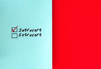 Choices to tick off : Introvert VS Extrovert on blue paper, with copy space on red paper at right...