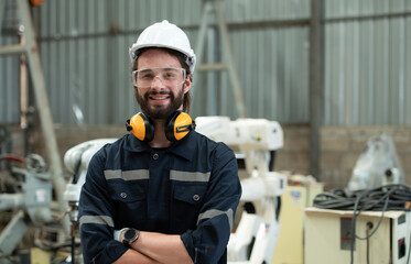 Young male engineers are manipulating a welding robot hand. By combining welding manipulation with...