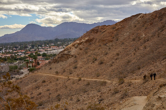 Walking path for hiking in the mountains near Palm Springs California with buildings in the valley on a cloudy day