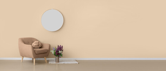 Comfortable armchair and vase with flowers near beige wall. Banner for design