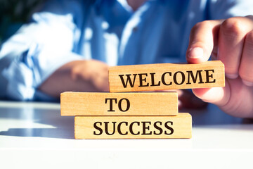 Wooden blocks with words 'Welcome to success'.