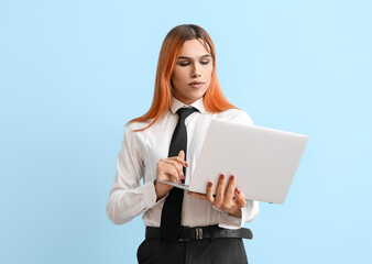 Obraz premium Beautiful transgender secretary with laptop on blue background