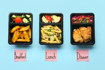 Food containers with different meal and sticky notes with words BREAKFAST, LUNCH, DINNER on color background
