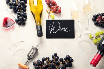 Flat-lay of red and white wine in glasses and corkscrews over grey concrete background, top view,...