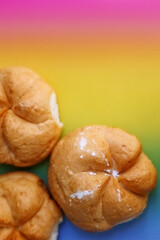 Delicious kaiser rolls on color background