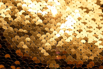 Abstract background of golden sequins with selective focus as texture