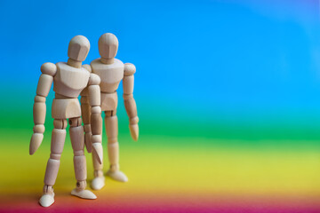 Wooden mannequin dolls on rainbow background