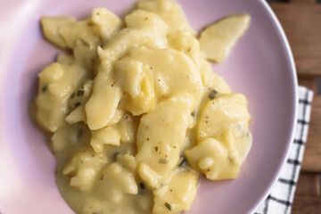 Plate with creamy potato salad on table, closeup