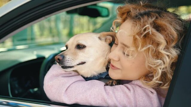 Girl Kissing Her Dog Sticking Outs Its Tongue On Car's Window. - close up