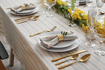 Plates with napkin and beautiful floral decor on served table