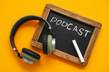Chalkboard with word PODCAST and headphones on orange background