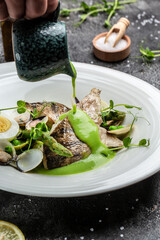 Fish dish - fried fish fillet of zander served with mussels, peas, asparagus and vegetable cream sauce. Restaurant menu, dieting, cookbook recipe