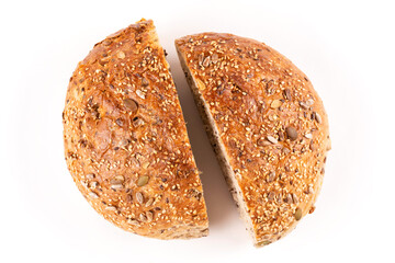 Two halves of round bread made of whole wheat flour with pumpkin seeds, sesame seeds, flax and sunflower seeds on a white isolated background. Bread without yeast, with sourdough. Pattern.