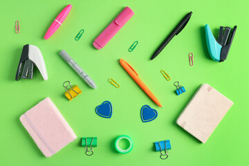 Composition with different stationery on green background