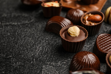 Different chocolate candies on black background, closeup