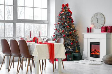 Christmas table setting with candle holders and fir trees in dining room