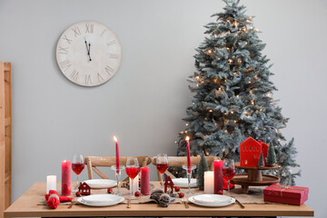 Interior of room with dining table, Christmas tree and clock