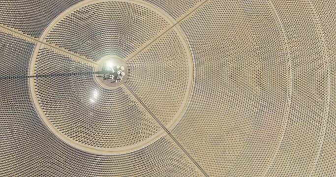 Solar thermal power plant. Renewable energy production. Solar energy. Aerial view of central power plant and industrial facilities surrounded by many reflecting mirrors. Sun moving. 3D rendering.