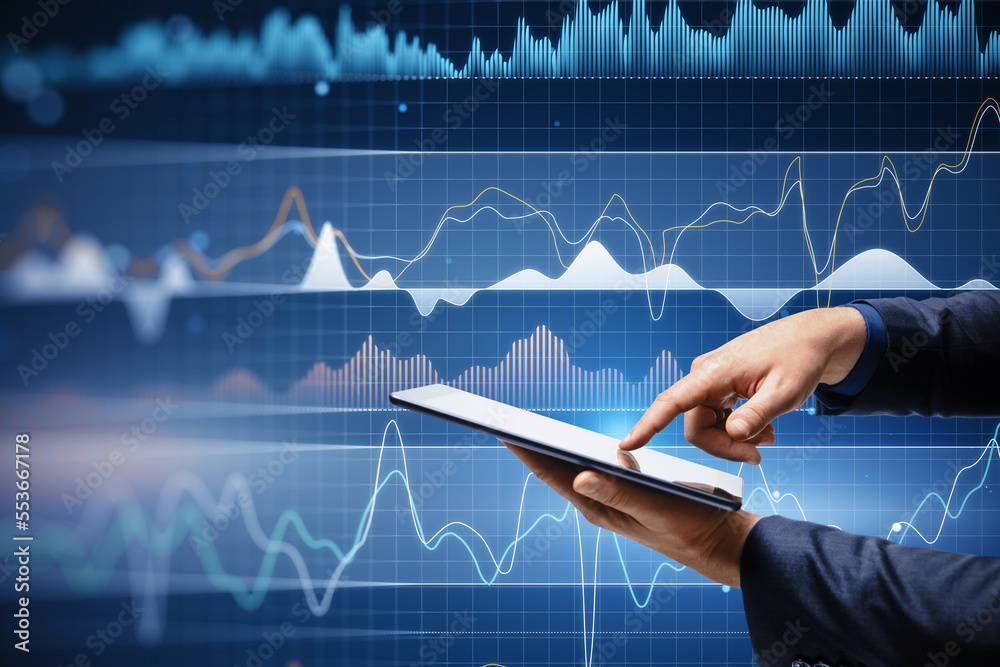 Poster close up of businessman hand using tablet with digital business graph hologram on blurry blue backgr