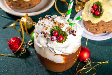 Christmas pudding latte. Sweet coffee drink with whipped cream, vanilla custard creme anglaise, fruit pudding syrup, styled like traditional Christmas english fruit pudding, on cozy decorated backgrou