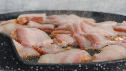 Bacon slices on a frying pan