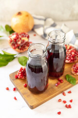Healthy drink diet immunity vitamins or vegetarian food concept. Pomegranate juice in glass bottles and fresh pomegranate fruits.