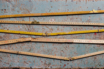 Vintage folding rulers on a worn wooden background