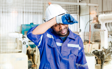 African american black male worker engineer working in electric robotic welding factory where...