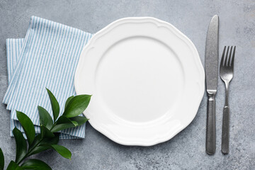 White plate with silverware and napkin. Table setting, elegant dining plate. Top view, copy space