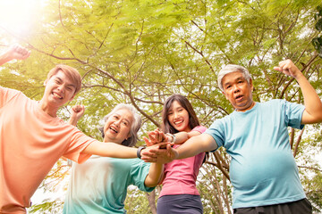 Fototapeta premium Happy asian family : Parents and sons and daughters join hands in exercising energy for healthy and happy minds in the park.