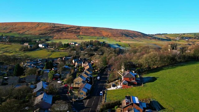 Aerial drone video footage of the small quite village of Denshaw, a typical rural village in the heart of the Pennines. Showing old houses road junction, village church and public house.