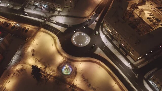 A night drone flight over an illuminated city. The city of Valmiera from above in winter