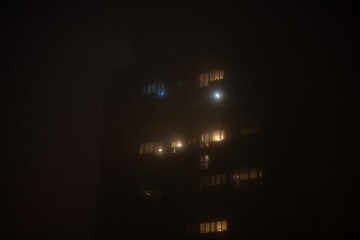 Smog lies over the residential building in Belgrade city at night. Poor visability, smog caused by air pollution. Emissions of plants and factories.