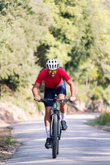 young cyclist training hard with his mountain bike on a forest road, concept of freedom and sport in nature, copy space for text