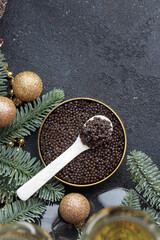 Black caviar in a mother-of-pearl spoon with Christmas decoration