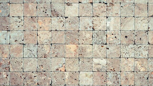 Square stones surface background Seamless Loop. Travertine masonry tiles cladding wall texture.