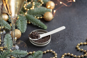 Black caviar in a mother-of-pearl spoon with Christmas decoration