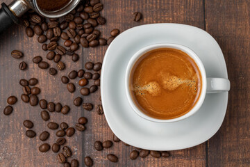 Fresh espresso coffee together decorated with coffee beans on wooden table