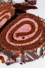 Slice of chocolate sponge cake roll with berry custard