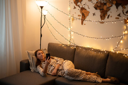 Beautiful Girl Using Smartphone While Laying On Couch At Home