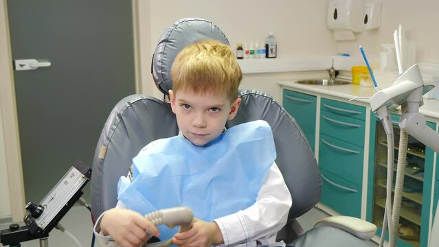 Dentist using nitrous oxide in dental clinic while treating young patients with milk teeth. Little boy thumbs up. Relaxation of patient before surgical or dental procedures. 4 k video