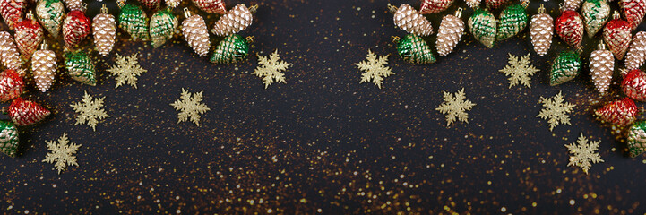Christmas decorations in the form of golden, red, green cones and snowflakes on a black background...
