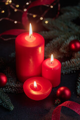 Obraz na płótnie Canvas Red candles on dark background with christmas decoration