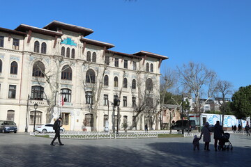 Obraz premium Tall building with windows placed in local park with trees 