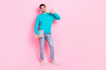 Full length photo of nice young man hold netbook showing thumb up recommend dressed stylish blue...