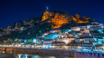 Evening view to Berat, historic city in the south of Albania at night with all lights flashing and white houses gathering on a hill. Captured during blue hour with the sky full of stars.