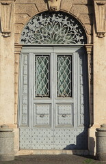 Fototapeta na wymiar Ornate Wooden Palace Entrance with Ironwork Grill Close Up in Rome, Italy