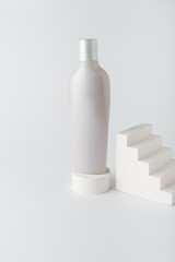 white care cosmetics bottle, shampoo or hair conditioner with concrete decorative elements. monochrome geometrical composition