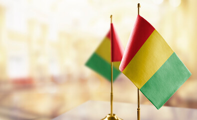 Small flags of the Guinea on an abstract blurry background
