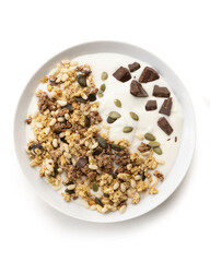 bowl of sweet cereal and seeds, with milk and chocolate, isolated on white background, top view